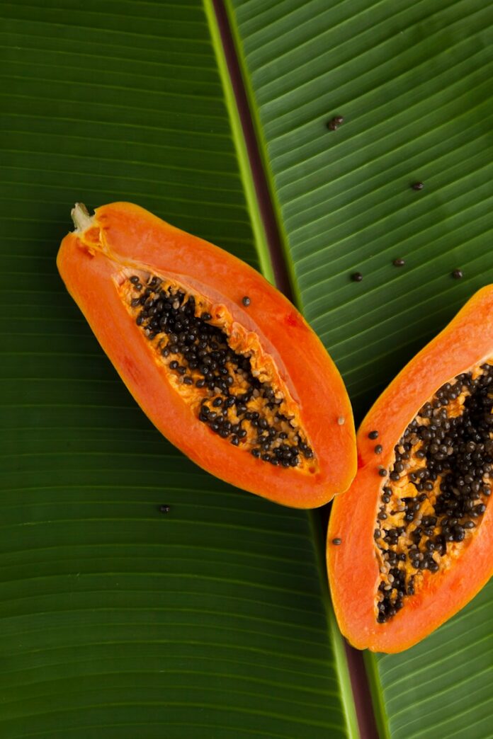 sliced papaya on green banana leaf